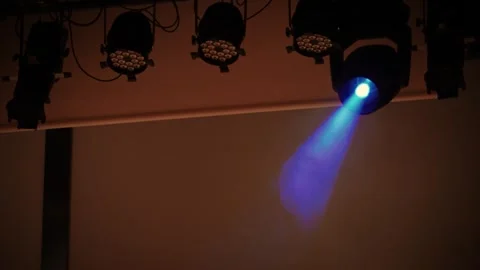 Stage spotlight emitting color changing beam through smoke Stock Footage 346350949