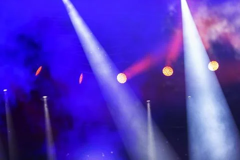 Stage white beams of light on dark blue background. Stage lighting for a conc Stock Photos