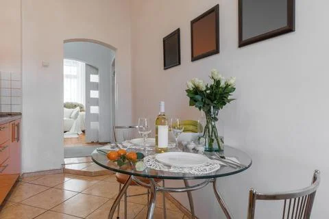 Staged Glass Dining Table in Kitchen with Corridor View 스톡 사진