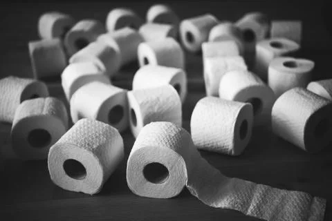 Staged stack of white tissue toilet paper rolls, black and white photo Stock Photos