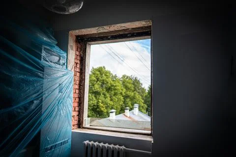 Stager preparing interior with plastic-wrapped furniture Stock Photos