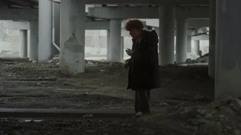 Staggering Young Man Lighting Cigarette and Smoking under Bridge Stock Footage 284258046