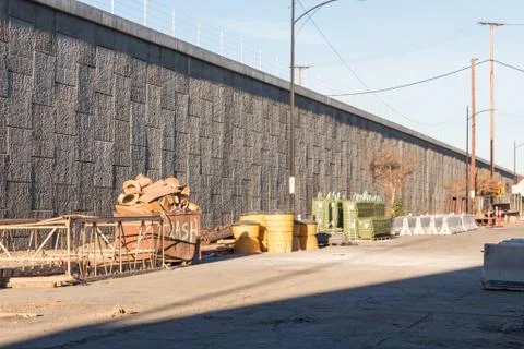 Staging area of road construction materials behide a concrete retaining wall Stock Photos