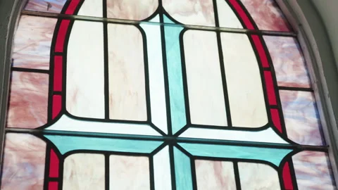 Stained glass window inside of a church featuring a cross Stock Footage 276378073