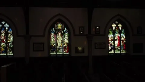 Stained glass windows in empty dark church Stock Footage 169976168