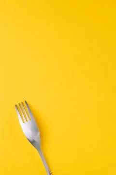 Stainless fork on yellow background Foto stock