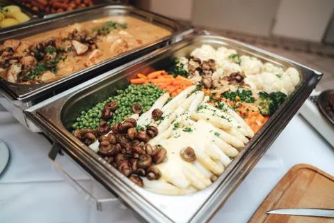 Stainless self-service buffet table with various meals, side dishes and Stock Photos