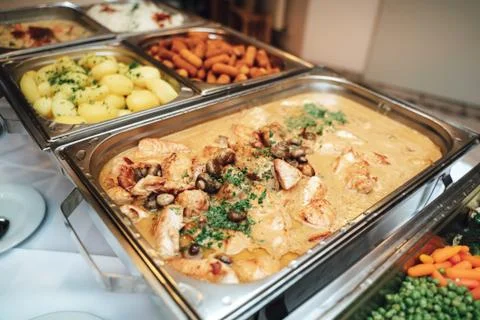 Stainless self-service buffet table with various meals, side dishes and Stock Photos