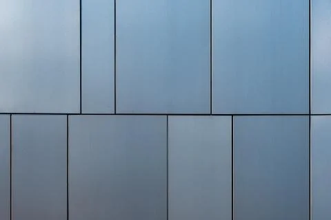 Stainless steel facade cladding shining in different grey and blue tones buil Stock Photos