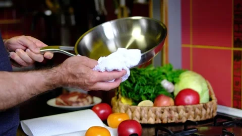 Stainless steel pan wiped with kitchen towel by chef before cooking on clean Stock Footage 345169543