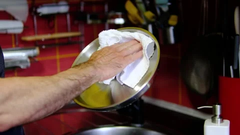 Stainless steel pan wiped with kitchen towel by chef before cooking on clean Stock Footage 345171437