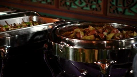 Stainless steel serving trays on dramatically lit buffet Stock Footage 124267344