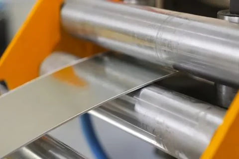 Stainless steel sheet inserted into, rollers for feeding into the press machi Stock Photos