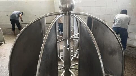A stainless steel structure with individuals using it, likely a public rest.. Photos