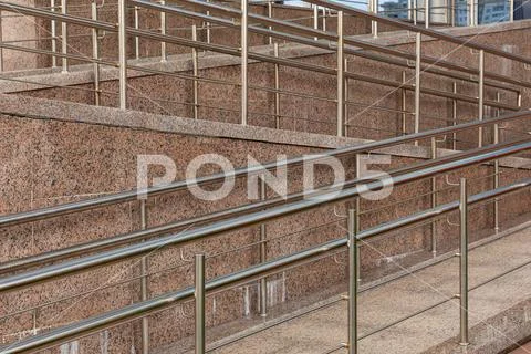 Stainless steel wheelchair ramp guard, concrete entrance slip road Stock Photos