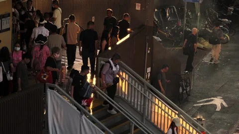 Stair of a train station when sun is setting, cigarette bin with smokers 02 Stock Footage 254239824