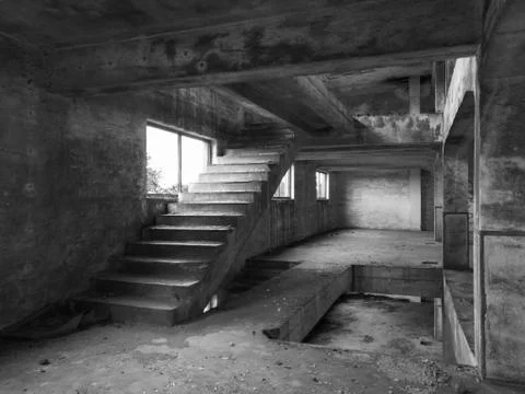 Staircase between floors in an empty messy industrial warehouse Stock Photos