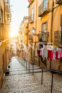 Staircase in the cobblestone street in Lisbon. Hanging laundry in typical narrow Stock Photos