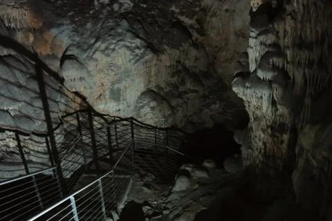 Staircase going deep into the cave, beautiful illuminated formations inside o Stock Photos