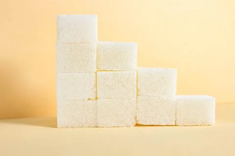 A staircase lined with white sugar cubes on a beige background. Foto stock