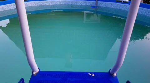 The staircase is located in a round frame pool, which is filled with clean, t Stock Photos