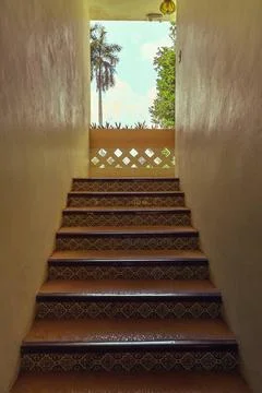  Staircase with patterned tiles leading up to a small balcony with tropica... Stock Photos