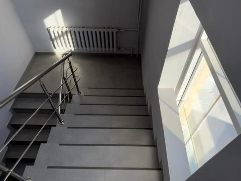 A staircase with a window above it Stock Photos