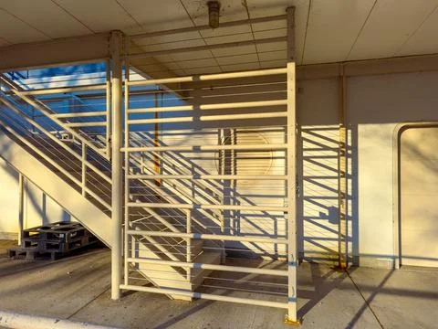 Stairs and shadows create lines in sunlight near a building at morning time Stock Photos