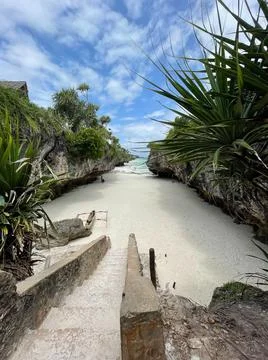 Stairs between rocks heading to a beach. Zanzibar. travel to an exotic countr Stock Photos
