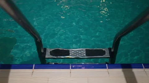Stairs to the empty clean blue pool in the hotel, where there are no people. Stock Footage 259574640