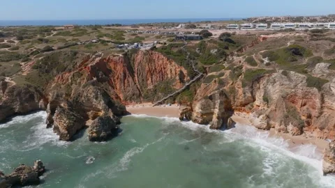 Stairs guide tourists down to secluded beach of praia da dona ana algarve, Stock Footage 247876809
