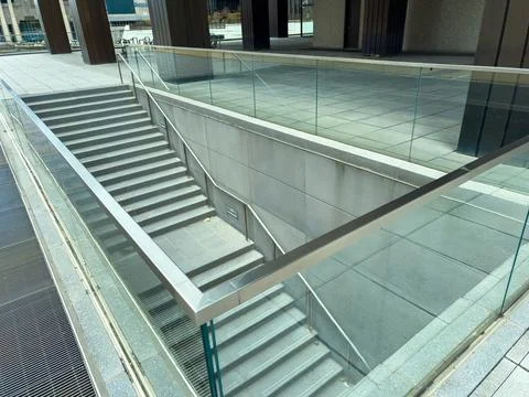 Stairs lead down to a lower level in a public building during daylight hours Stock Photos