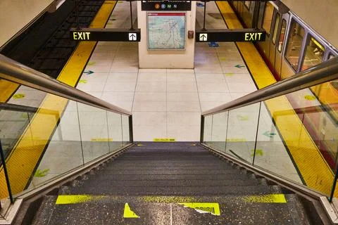 Stairs leading down to subway with exit signs and map of area on board and train Stock Photos