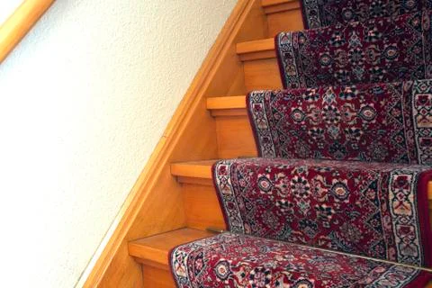 Stairs with red pattern carpet strip, old vintage wooden staircase, antique Stock Photos