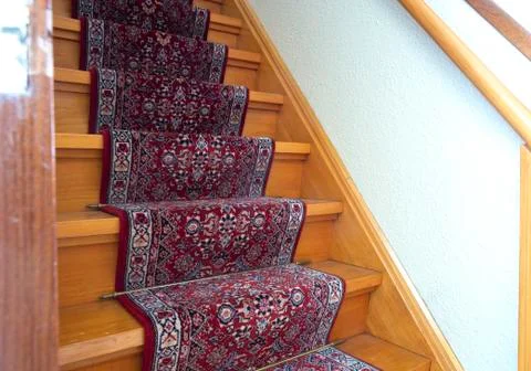 Stairs with red pattern carpet strip, old vintage wooden staircase, antique d Stock Photos