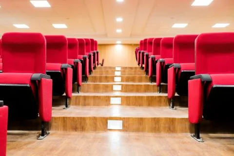 Stairscase gallery between empty rows of seats of an auditorium with red Stock Photos