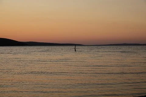 A stake in the ocean at sunset Stock Photos