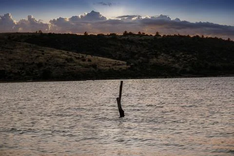 A stake in the ocean at sunset Stock Photos