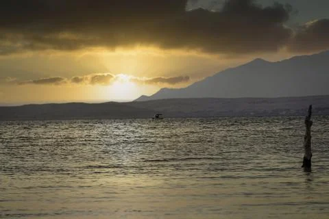 A stake in the ocean at sunset Stock Photos