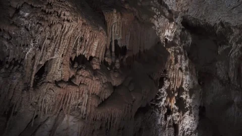 Stalactites and flowstone formations inside deep limestone cave system. Video stock 337599640