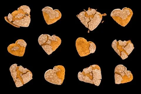 Stale, dry gingerbreads in shape of heart with cracked glaze with crumbs. Iso Stock Photos