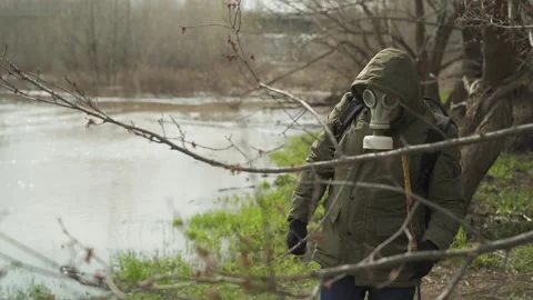 Stalker in a gasmask, a hoodie. the average plan goes along the river Video stock 130523767