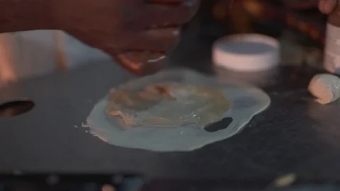 Stall vendor applying sauce while preparing Zanzibar pizza at the stall Stock Footage 85769555