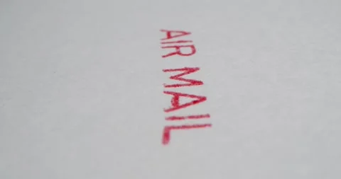 A stamp AIR MAIL is placed on a sheet of white paper, close-up Stock Footage 251589382