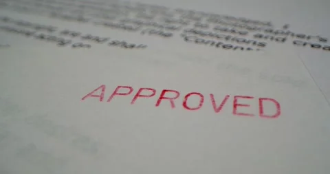 A stamp APPROVED is placed on a sheet of white paper, close-up Stock Footage 251589338