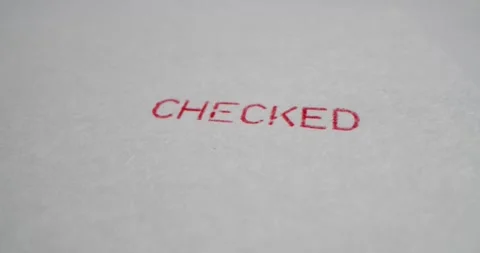 A stamp CHECKED is placed on a sheet of white paper, close-up Stock Footage 251588735