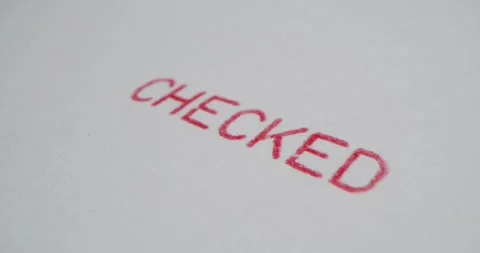 A stamp CHECKED is placed on a sheet of white paper, close-up Stock Footage 251589437