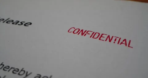 A stamp CONFIDENTIAL is placed on a sheet of white paper, close-up Stock Footage 251589259