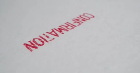 A stamp CONFIRMATION is placed on a sheet of white paper, close-up Stock Footage 251589363