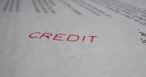 A stamp CREDIT is placed on a sheet of white paper, close-up Stock Footage 251589034
